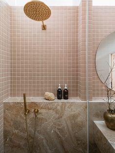 a bathroom with pink tile and gold fixtures