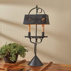 a table with a lamp and potted plant on it next to a cutting board