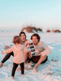 a man, woman and child are sitting in the snow with an old polaroid