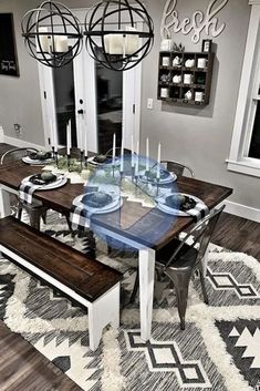 a dining room table with two benches in front of it and an area rug on the floor