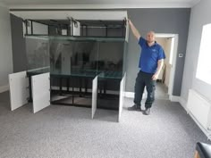 a man is standing in an empty room with shelves and cupboards on the wall