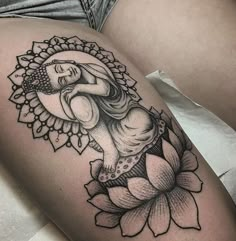 a woman's thigh with a tattoo on it and a flower in the foreground