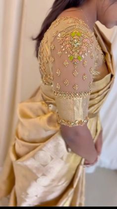 the back of a woman's dress with gold and green beading on it