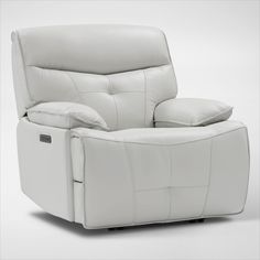 a white reclining chair with pillows on it's back and armrests