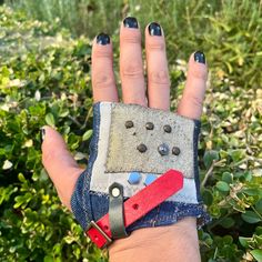 a woman's hand wearing a pair of blue jeans with buttons on the wrist