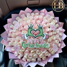 a bouquet of pink roses in the back seat of a car with merry grinmas written on it