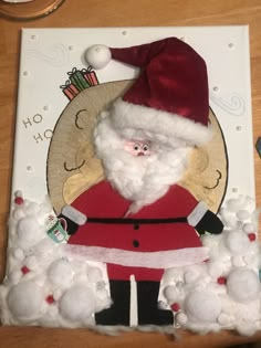 a card with a santa clause on it and cotton balls in the foreground that says merry christmas