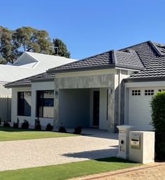 a white house with two garages on the front and one car parked in front