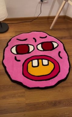 a pink rug with an angry face on it