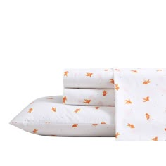 three sheets with orange foxes on them and one white pillow case in the foreground