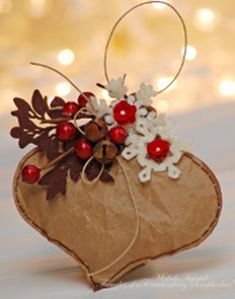 an ornament shaped like a heart with red berries and white flowers on it