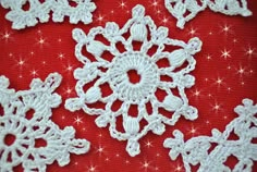 white crocheted snowflakes on red fabric