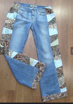 a pair of jeans sitting on top of a wooden floor