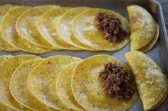 some tortilla shells are on a pan and ready to be cooked in the oven