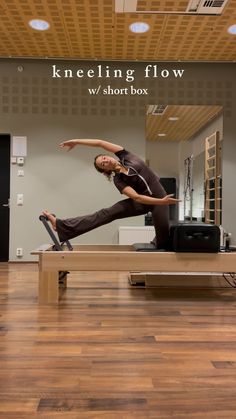 a man is doing a split on a bench in the middle of a dance studio