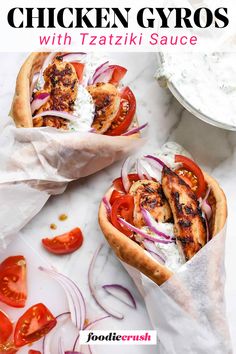 two chicken gyros with tomatoes, onions and red onion on a white table