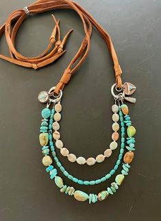 I love these "Sundance style" necklaces because all of these beautiful stones are front and center, but the suede lace straps are comfortable on the neck and so light you'll hardly know you're wearing it!  This piece features excellent quality turquoise nuggets from the Hubei mine in China. These all-natural, undyed AAA quality stones have some of the nicest color and natural patina I've seen. the piece is anchored by two rustic silver plate rings and small charms.  This necklace is fully adjustable with a snug, silver-tone slide bead, and can be extended up to approx 36" total (or a roomy 18" from nape to longest point.) So versatile it stacks with anything, but gorgeous just by itself! Sundance Style Jewelry, Sundance Jewelry Catalog, Sundance Jewelry, Sundance Style, Sundance Catalog, Jewelry Catalog, Beautiful Stones, Lace Straps, Unisex Gift