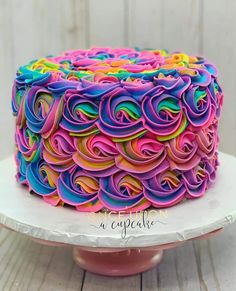 a multicolored cake with swirls on it sitting on top of a plate