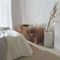 a white bed sitting next to a wooden dresser