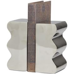 A small piece of decor that make a big difference to give your home an instance refresh. Give your surface space a finishing touch with these beautifully crafted bookends. Give your surface space a playful look with these bookends, either holding books in pace, or used simply as a unique sculpture. Designed with felt or rubber stoppers at the base that prevent scratching furniture and table tops, as well as sliding around. This item ships in 1 carton. Aluminum bookends make a great gift for any occasion. Suitable for indoor use only. This item ships fully assembled in one piece. Made in India. This silver colored non skid bookends comes as a set of 2. Contemporary style. The Novogratz 2-Pack Silver Aluminum Modern Decorative Bookends | 820401 Unique Bookends, Decorative Bookends, Unique Sculptures, Minimalist Aesthetic, Table Tops, Joss And Main, Aluminum Metal, Decorative Objects, Bookends