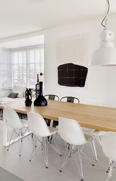 a dining room table with white chairs around it