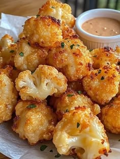 a plate full of fried cauliflower with dipping sauce