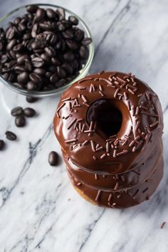 chocolate frosted donuts stacked on top of each other with coffee beans in the background