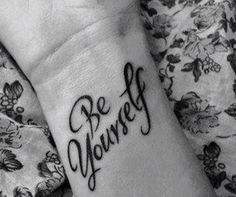 a woman's wrist tattoo with the word be yourself written in cursive font