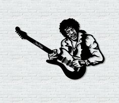 a black and white image of a man playing guitar on a brick wall with his eyes closed