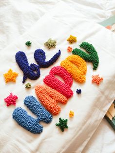 there are letters made out of crochet on the bed sheet that says happy