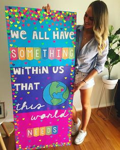 a woman holding up a sign that says we all have something within us that world needs