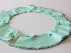 a circle made out of fabric with buttons on the side and thread running through it