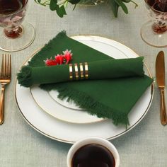 a place setting with green napkins and silverware