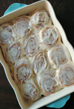 a pan filled with cinnamon rolls sitting on top of a blue plate