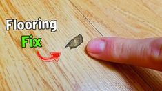 a finger pointing at a piece of wood with the word flooring fix on it