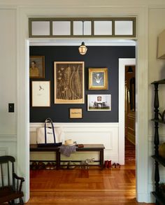 an open door leading to a living room with pictures on the wall and wooden floors