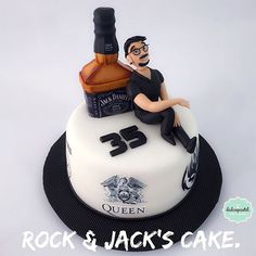 a cake with a man sitting on top of it that is made to look like a whiskey bottle