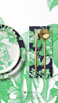 a green and white place setting with gold utensils on the plate next to it