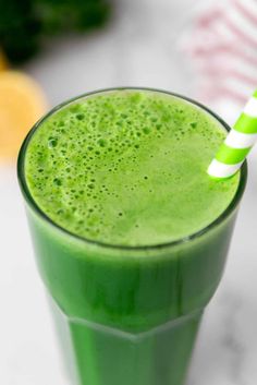 a green smoothie with a striped straw in it