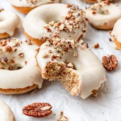 there are many doughnuts that have been cut in half and topped with pecans