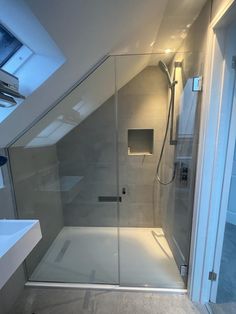 a walk in shower sitting next to a sink under a skylight on top of a roof