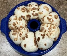 a blue bowl filled with white and brown desserts on top of a marble counter