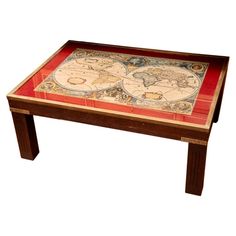 an old world map on a wooden table with red and gold trim around the edges