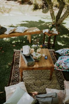 a wooden table sitting on top of a lush green field