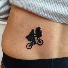 a woman's stomach with a small tattoo of a bicyclist on it