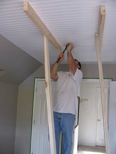 a man is working on the ceiling in his house