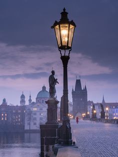 a lamp post on a cobblestone street with buildings in the background