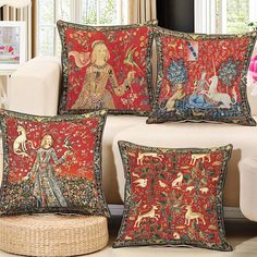 four decorative pillows on a couch in front of a window with an image of a woman