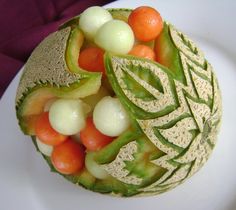 a watermelon carved with fruits and vegetables on it