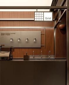 a coffee shop with stainless steel fixtures and wood paneling on the walls, along with an automatic coffee machine